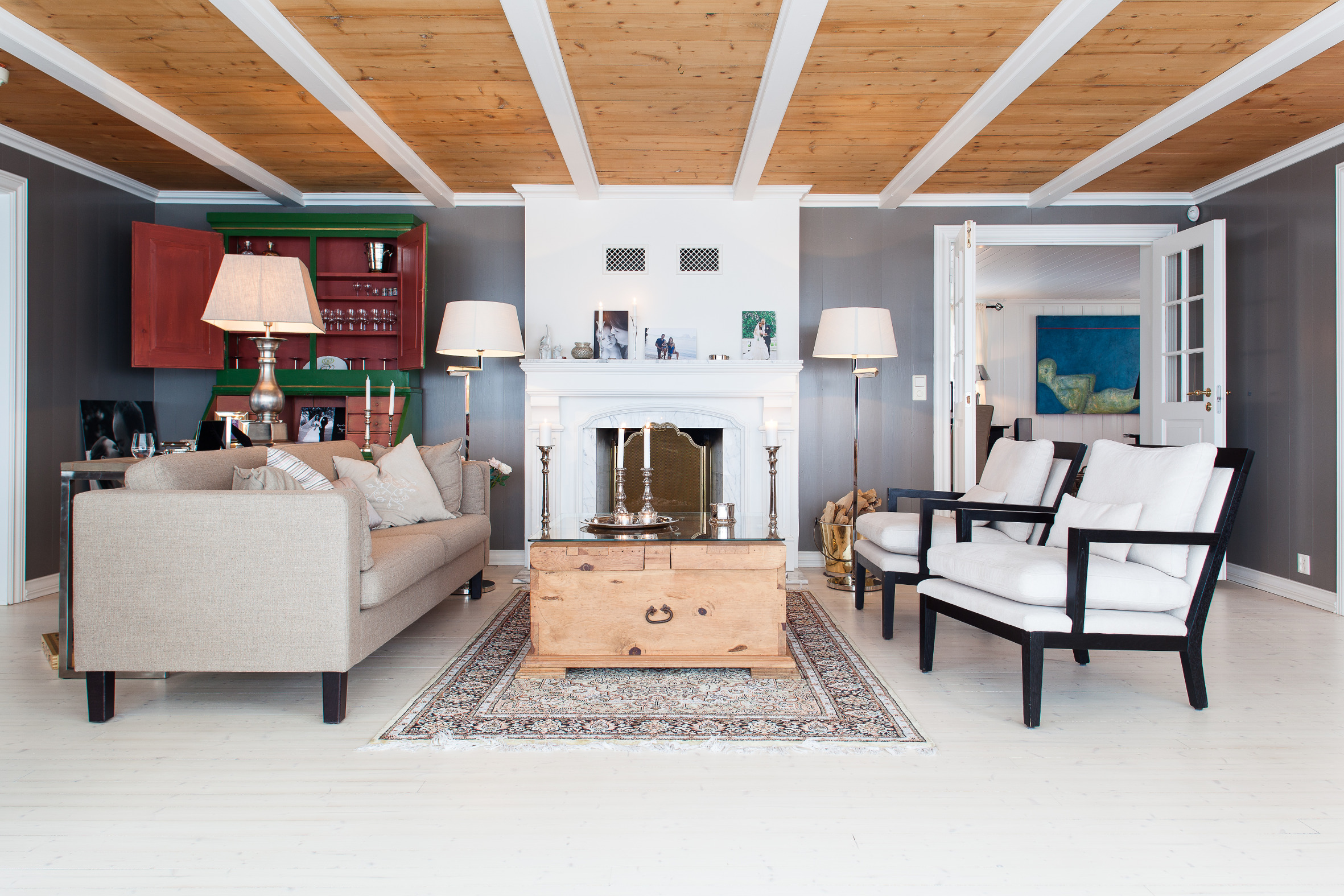 Mørke vegger i en varm farge danner sofistikerte rammer om gamle og nye møbler. 