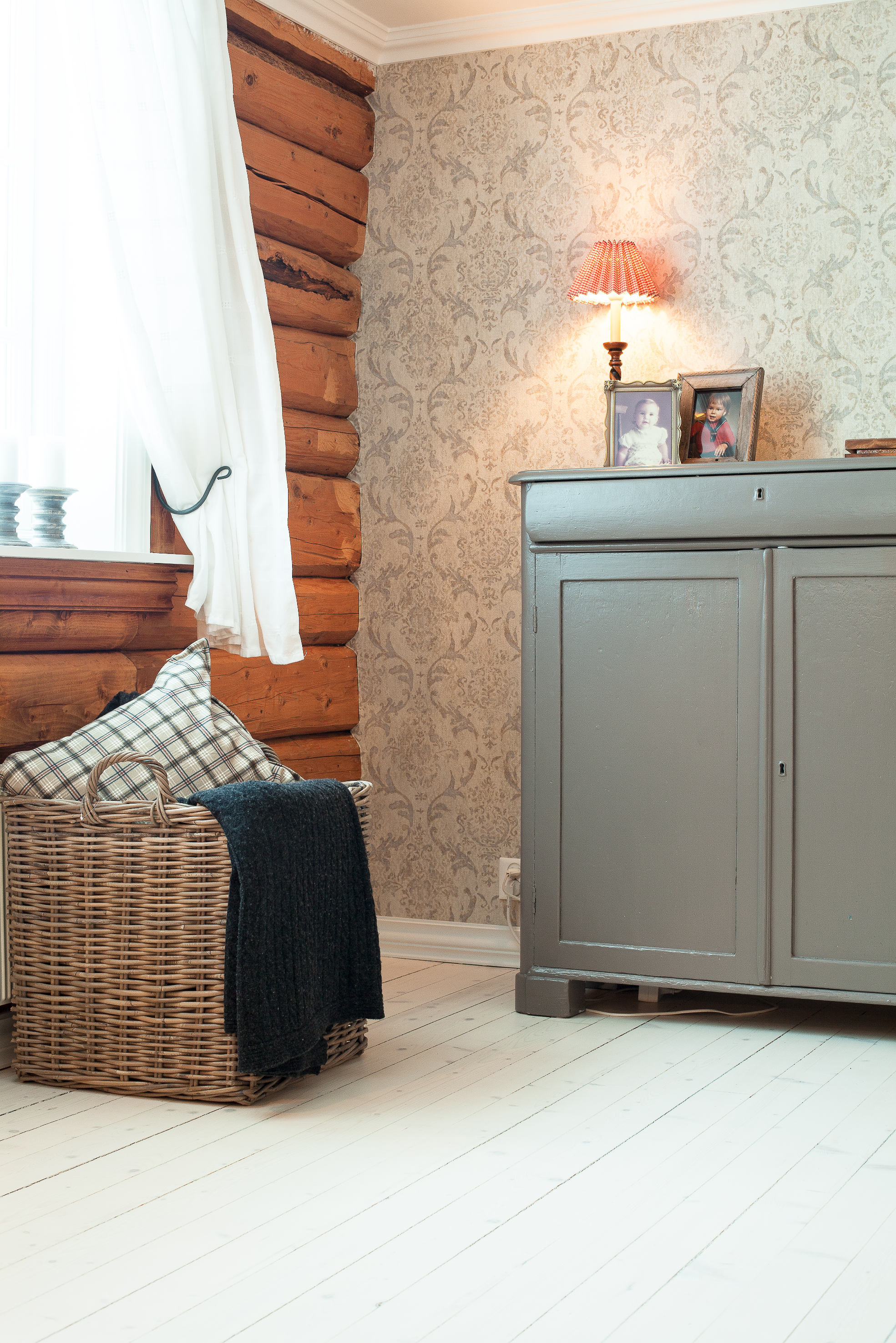 Tømmervegg fra fordums tid i sanselig møte med lekkert tapet og nymalt skap. 
