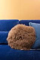 <b>PELS:</b> En rund, raggete pute skaper liv i sofaen. På messen så vi dem i mange varianter. Denne er fra Bloomingville.