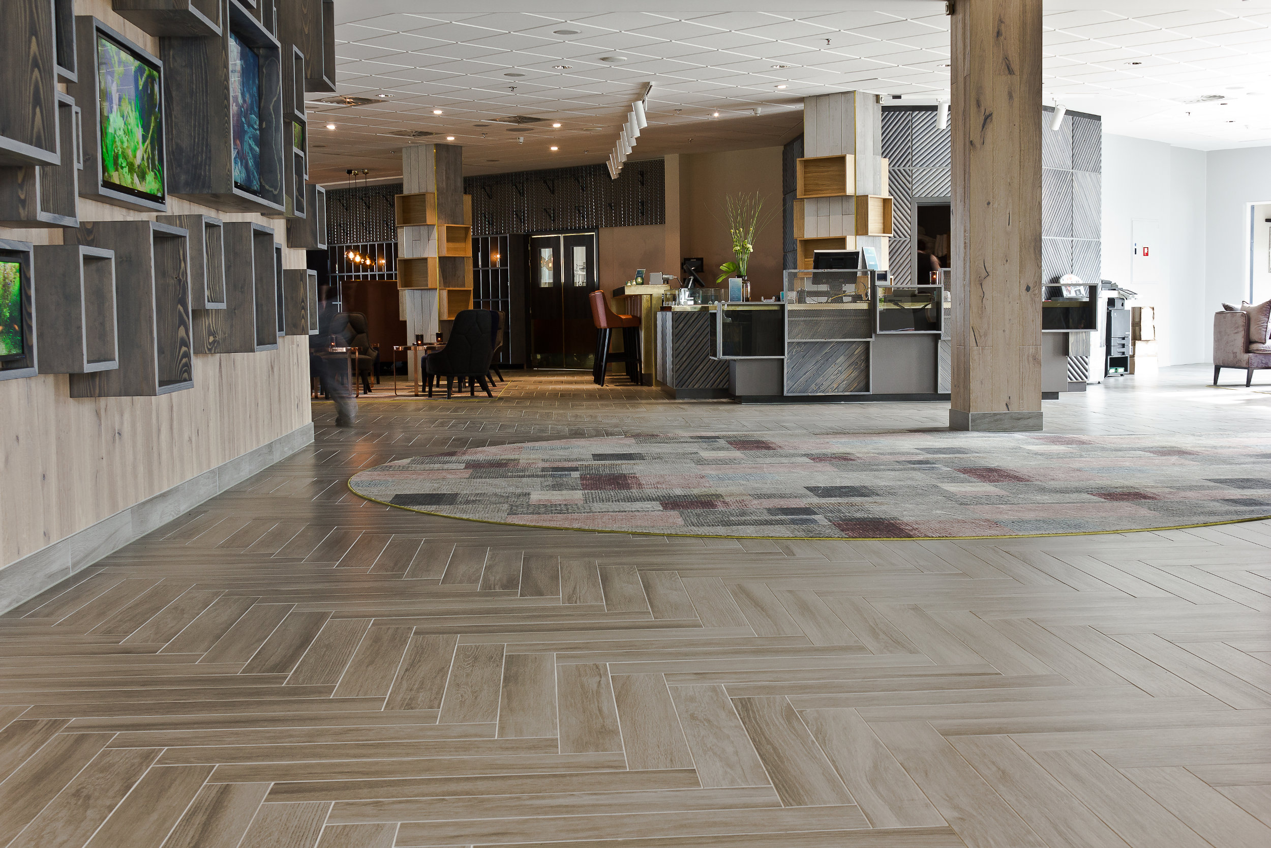 Hovedveggen er kledd med treparkett og dekorert med grå kasser som skal minne om drivved.