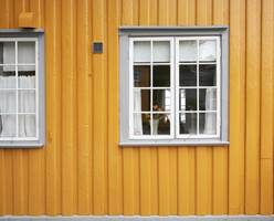 Grått på vindskier og vindusomramming gir et gult hus en fin og rolig helhet.