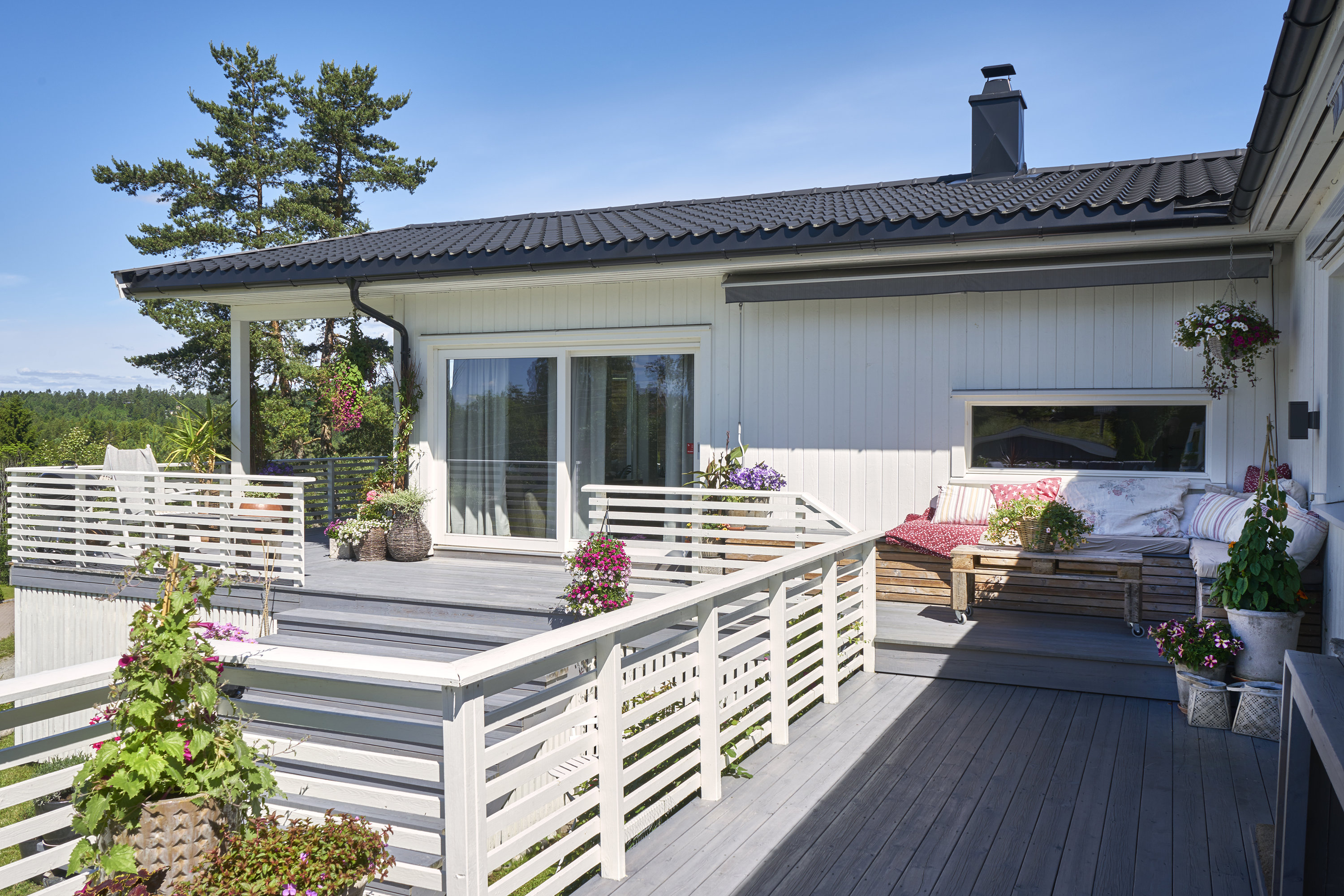 terrasse med rekkverk ved hvitt hus