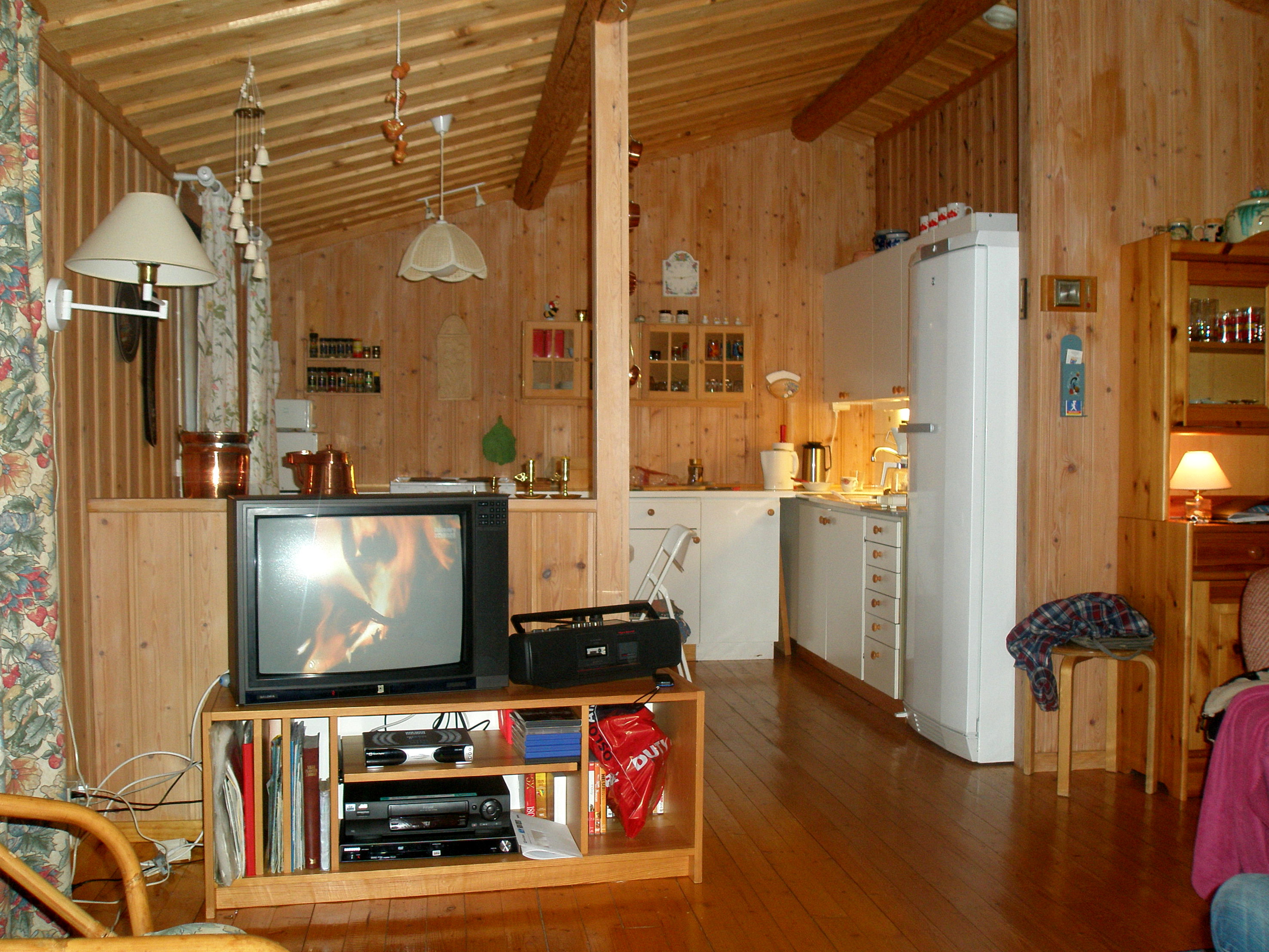 Kjøkken og spisekrok før. TV-en har måttet vike for en peisovn, som også fungerer som romdeler.