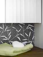 Mønsteret på våtromsvinylen gir rommet karakter, i fin kontrast til det hvitmalte panelet. 