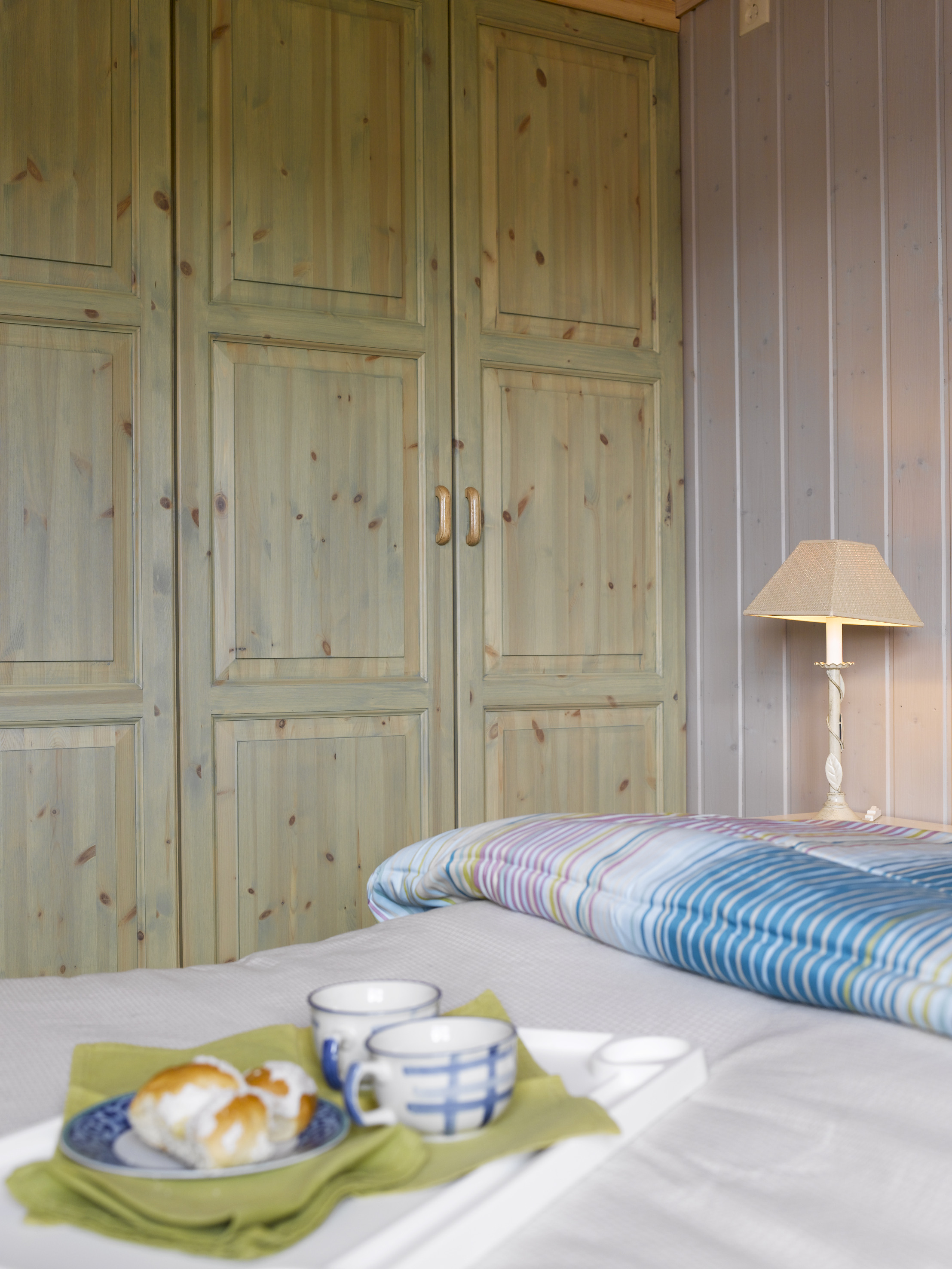 Skapene er bygget på stedet og påført en lys grønn panellakk, som matcher sengefargen og de øvrige grønnfargene i rommet. 