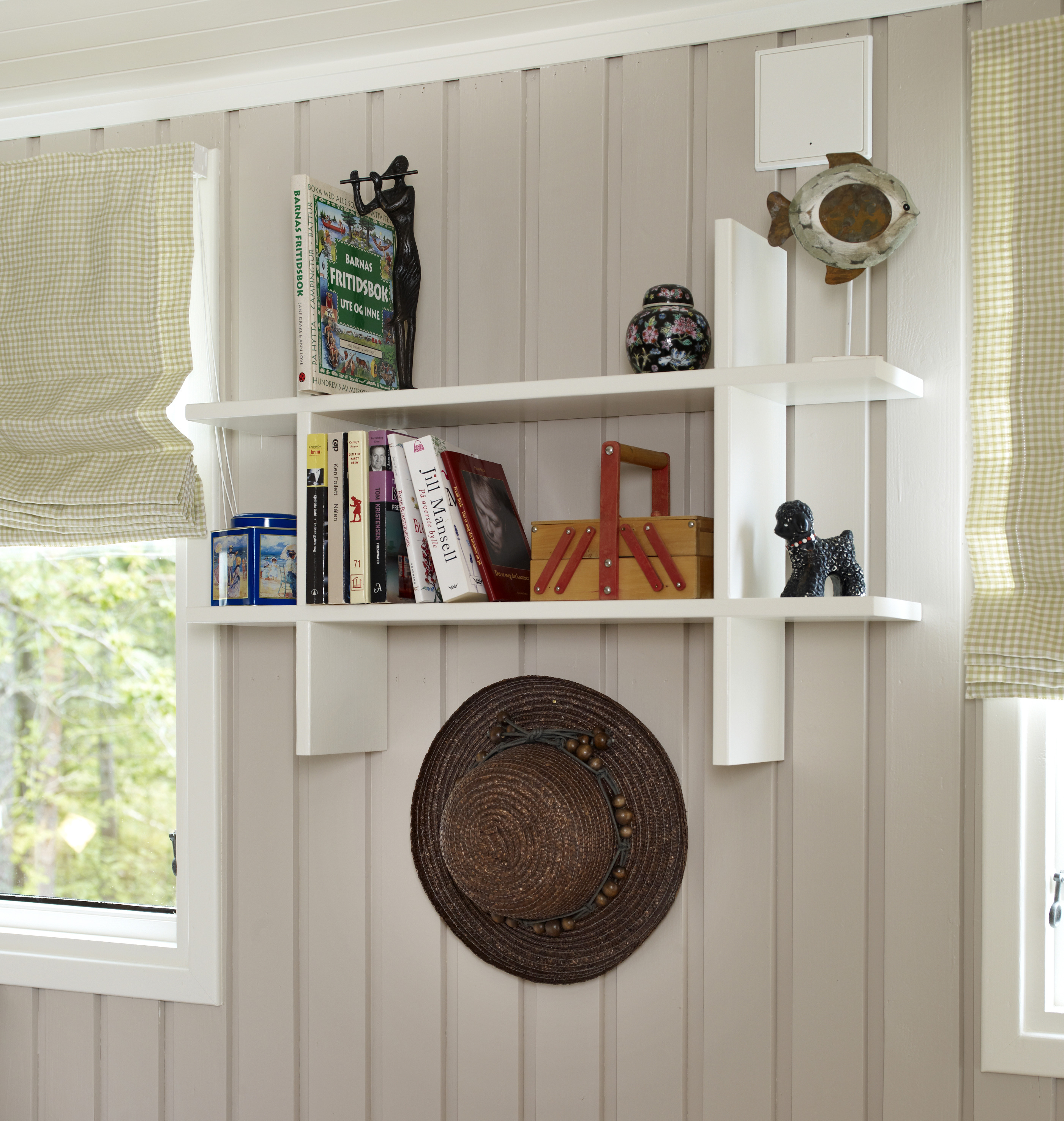 Åpne, hvitmalte hyller utgjør en stilig effekt på soverommet.