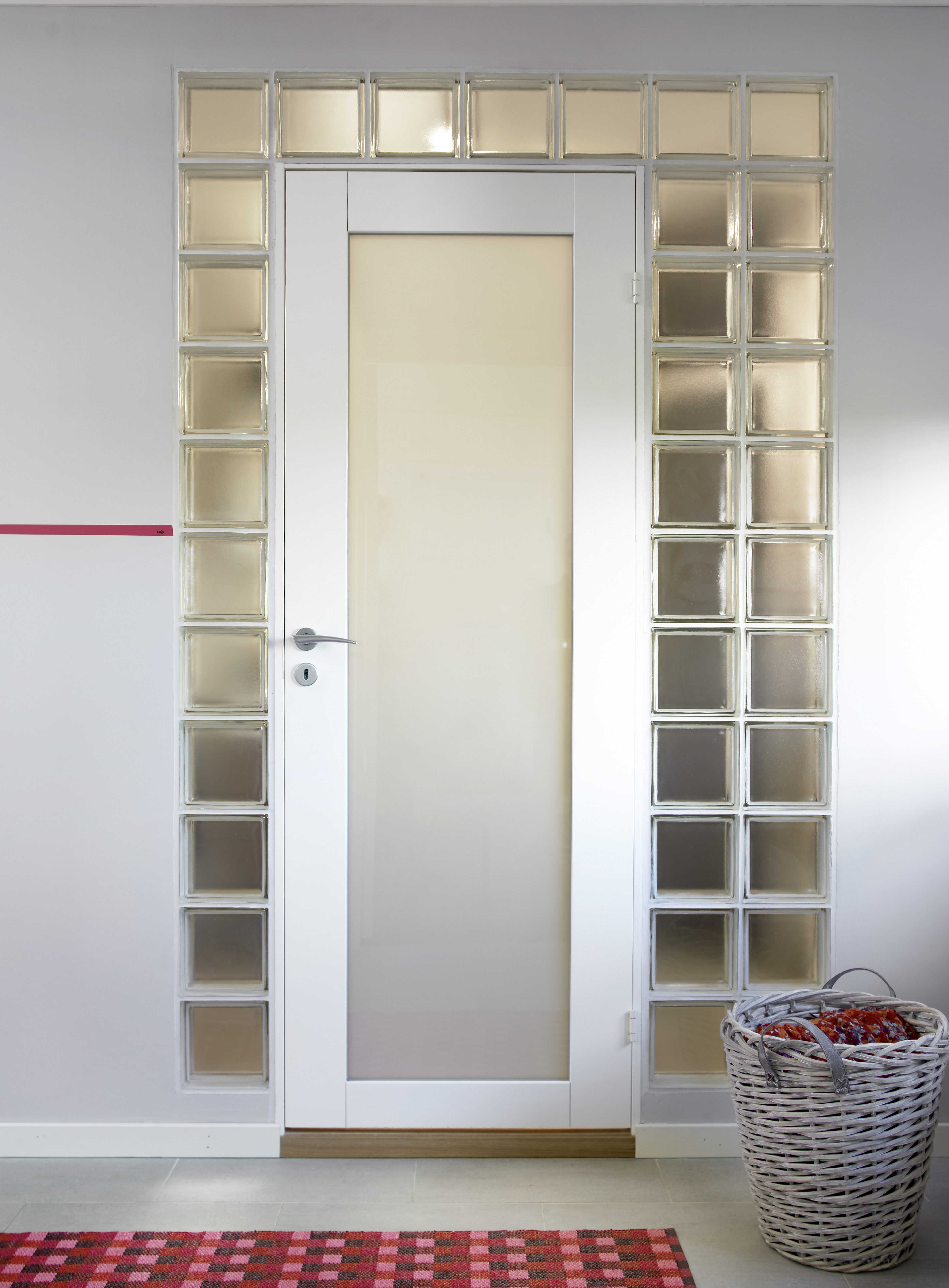 En elegant dørløsning forbinder entréen og våtrommet – en ramme av matt gassbyggestein omgir døren. Dette gjør romopplevelsen i entréen luftigere og bedrer lysforholdene på badet. 