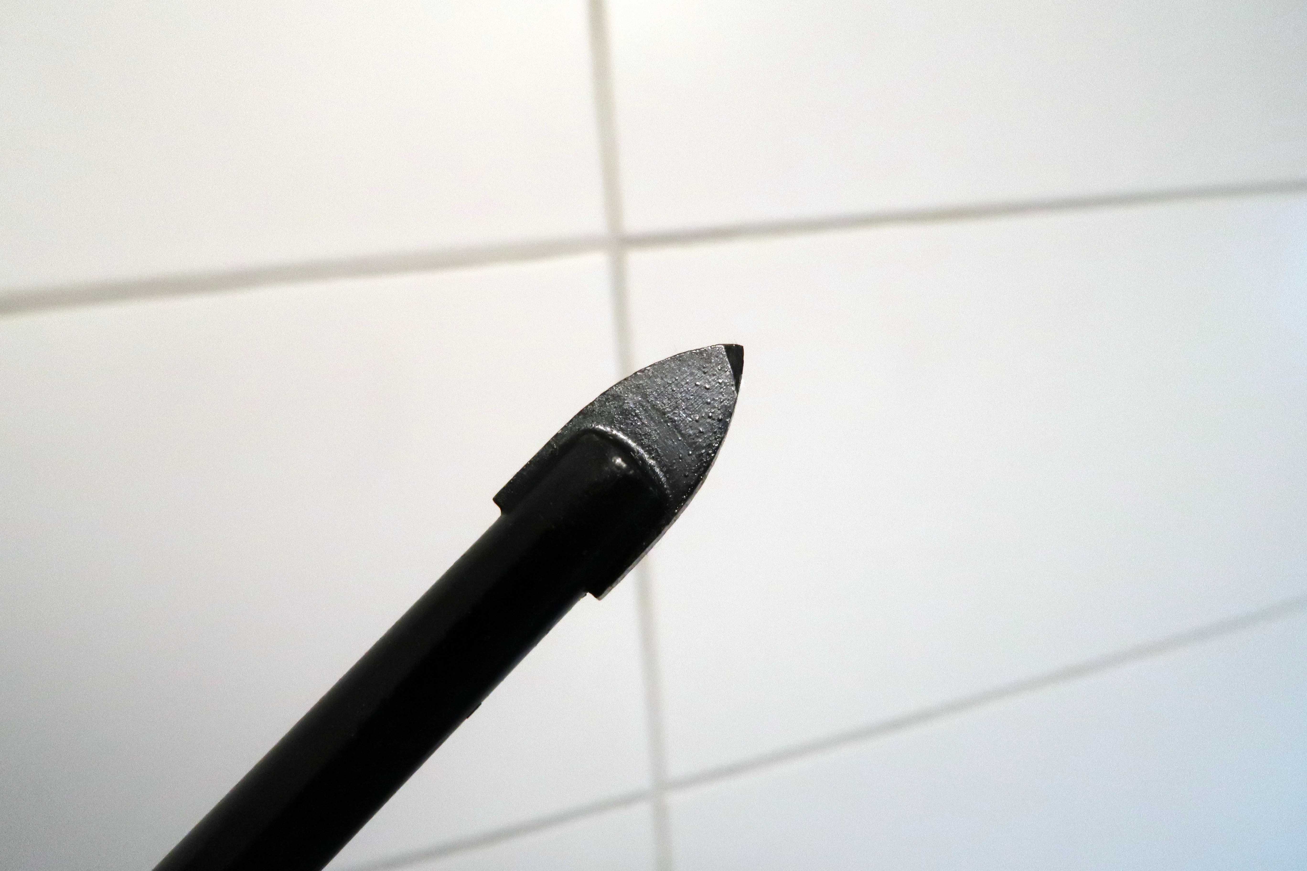 SKRAPER: Et flisebor er utformet som en pil. Det skraper seg inn i flisen. Pass på og ikke bore for langt inn. Fyll hullet med våtromssilikon før du trykker inn pluggen. Så kan du skru fast det som skal henges opp.