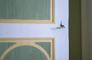 De rillede flatene i døren tar opp fargen på veggene i det grønne soverommet. Speilene aksentueres nydelig av en mild gul, mens hvitt ramtre markerer døren.