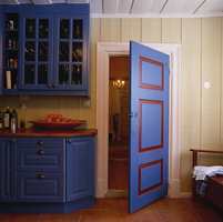 Også på kjøkkenet er taket malt hvitt, det samme er listene, vinduene og geriktene. Dørene ble malt i den samme blåfargen som innredningen, med speilene rammet inn av en dyp rødfarge.