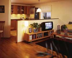 Moderne kjøkken og åpen stue. Halvveggen gjør rommene større samtidig som den skiller de.