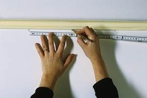 Stripene er 16 cm brede,og avstanden settes av med blyantmerker rett under taklisten og ved gulvlisten. Man kan også bruke loddesnor.