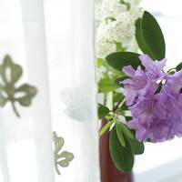 Fargerike, friske blomster og hvite lingardiner er nydelig sammen.