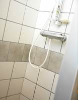 Gulvflisene er også brukt som veggfliser i dusjsonen for å bryte med de hvite. De er lagt i mursteinsmønster for å unngå forskyvninger i fugene, fordi det er noen få millimeter forskjell i størrelsen på gulv- og veggflisene.