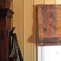 Liftgardinene i bomullsvelour er paisleymønstret. Fargene er varme og gir lunhet til rommet, og det tykke stoffet holder lyset ute når gardinen er trukket ned.