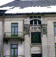 Typisk murgård i jugendstil med masker på fasaden og buede vinduer.