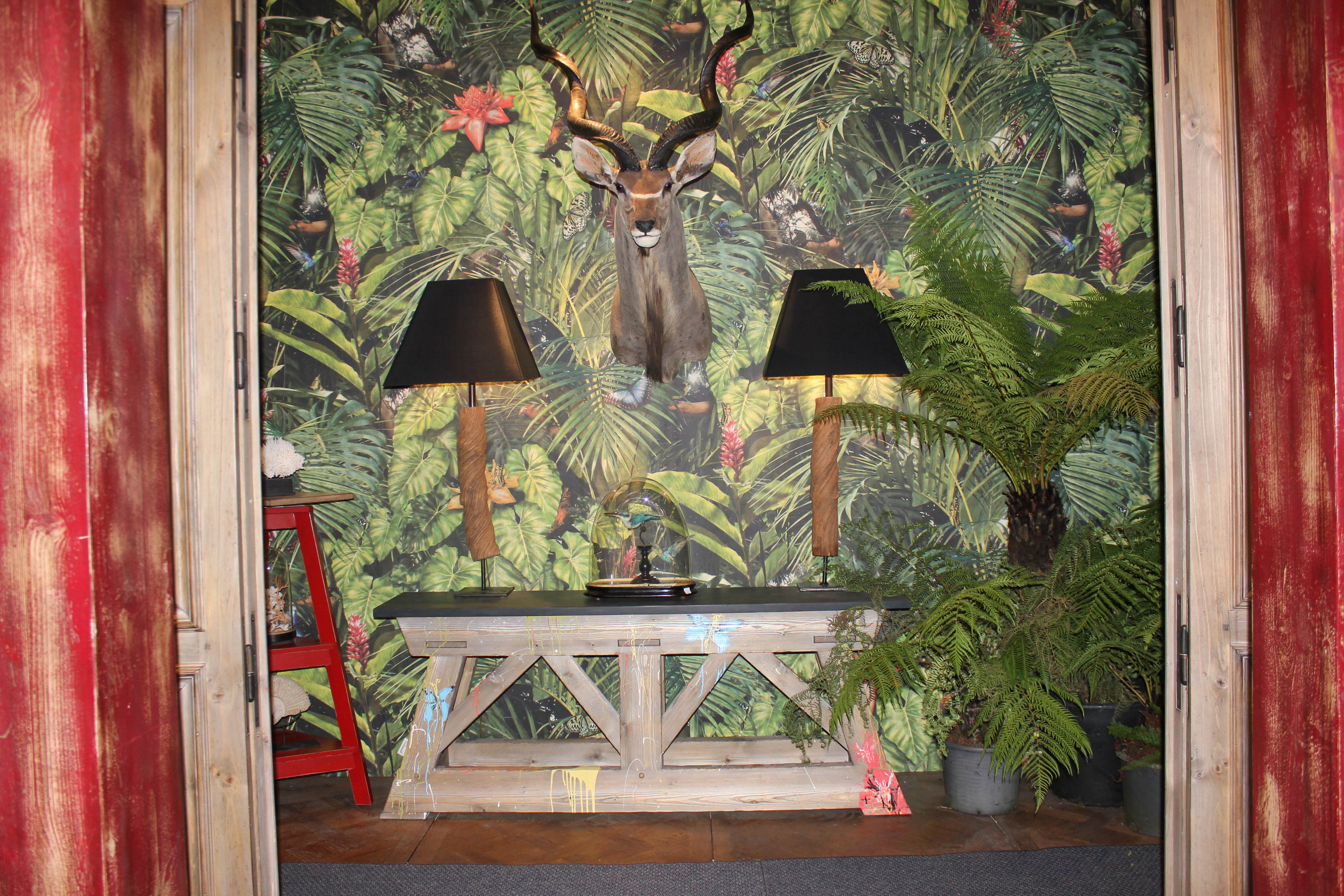 Fugler, planter og dyr i skjønn forening. Kikker man nærmere etter, er det et yrende liv blant alle vekstene. Og en mønstret vegg tåler lag på lag også utover i rommet.