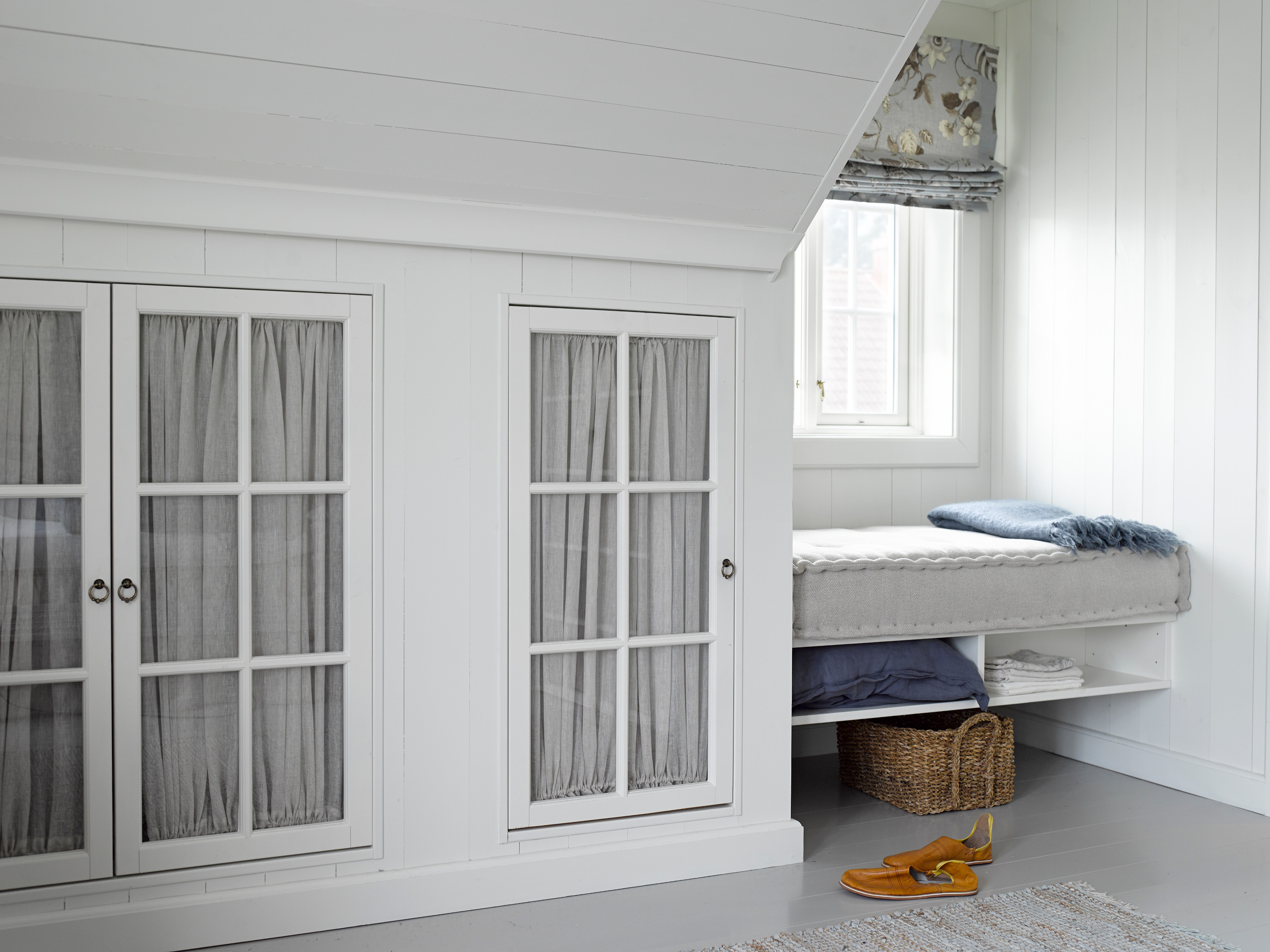 Skapdører med glass og gardin gir ekstra romfølelse, bryter opp og skaper litt ekstra dybde i veggen.