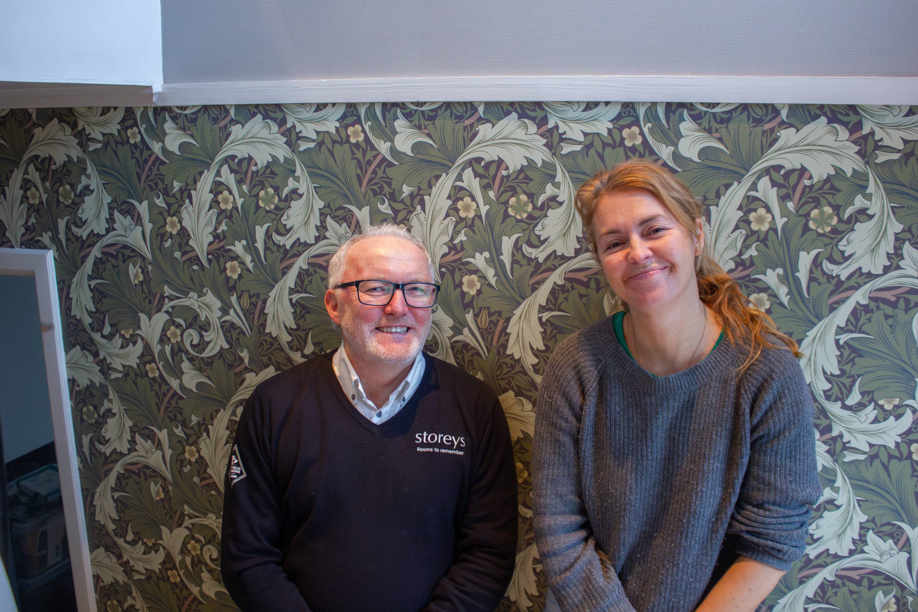 Charlotte og Roar poserer foran ferdig tapetsert vegg