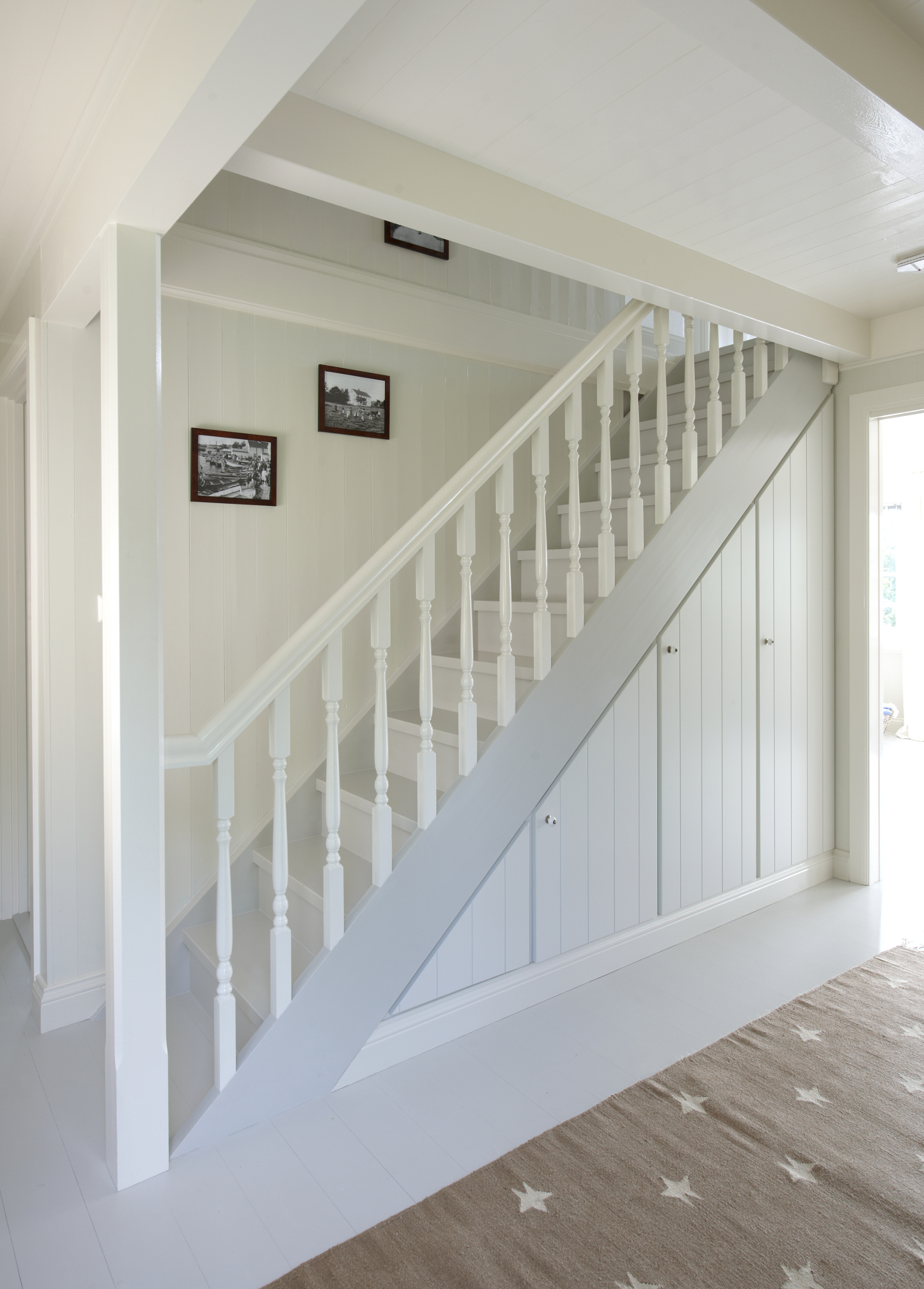 Lyst og vakkert – en helt utrolig forvandling, som skyldes farger og glansgrader. Praktiske skap fyller nå plassen under trappen.