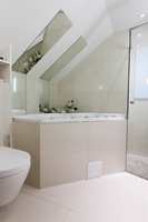 Speil i skråtaket bidrar til økt romslighet. I hyller over sisternen til WC er det plass til håndklær og ting. 