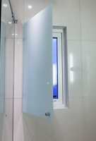 Vinduet i ytterveggen kan dekkes av en glassplate, og flisene går helt inn til karmen. Det gjør at vann fra dusjen ikke ødelegger vegg og vindu. 