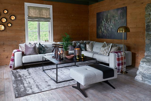 Lyst teppe med blank luv, kontrast til rustikk sofagruppe