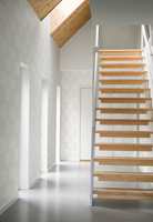 <b>NATUR:</b> Svale farger, blankt gulv og trapp i lyst tre skaper en moderne og ren atmosfære. Trappen er en varm kontrast og skaper liv og dybde i rommet. Tapetet er fra Borge/Engblad.