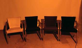 De samme stolene er belyst med lavtrykknatrium, som for eksempel benyttes til gatebelysning. Den guloransje fargen dominerer, uten å gjengi stolenes klare farger.
