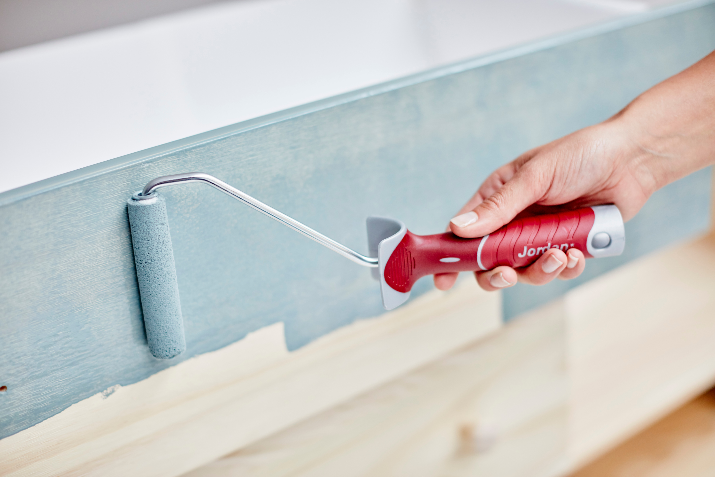 Bruk rull til de større flatene, og stryk ut med en fordriver (etterstryker).