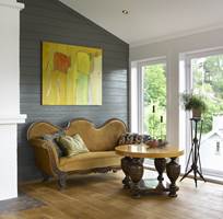 Runde former på sofa og bord står i sterk kontrast til det moderne maleriet og vinklene i rommet.