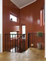 Den varme, rødoransje fargen nærmest omslutter en og skaper en spennende adkomst til stuen.