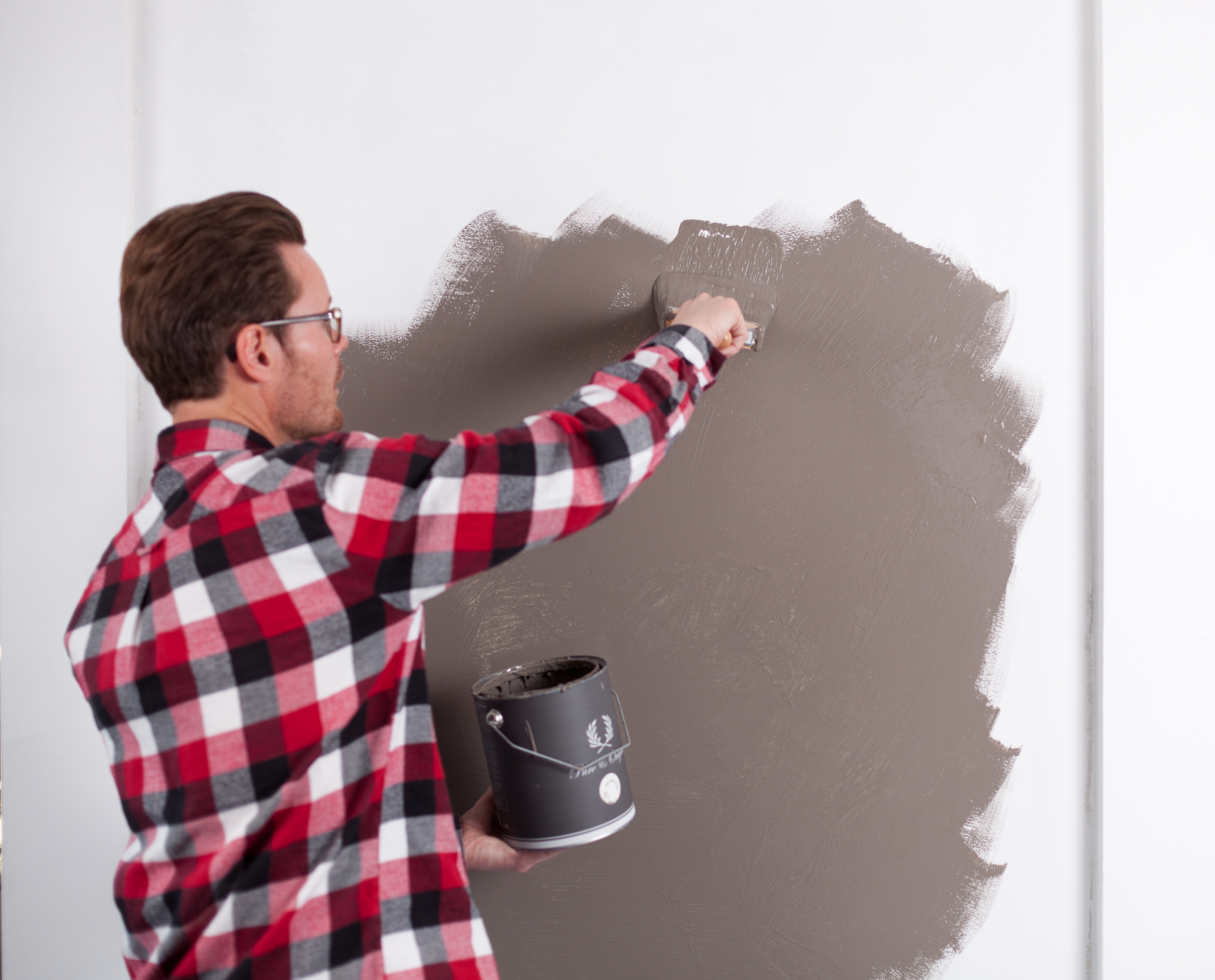 Påfør malingen på veggen med en rull eller en stor pensel.