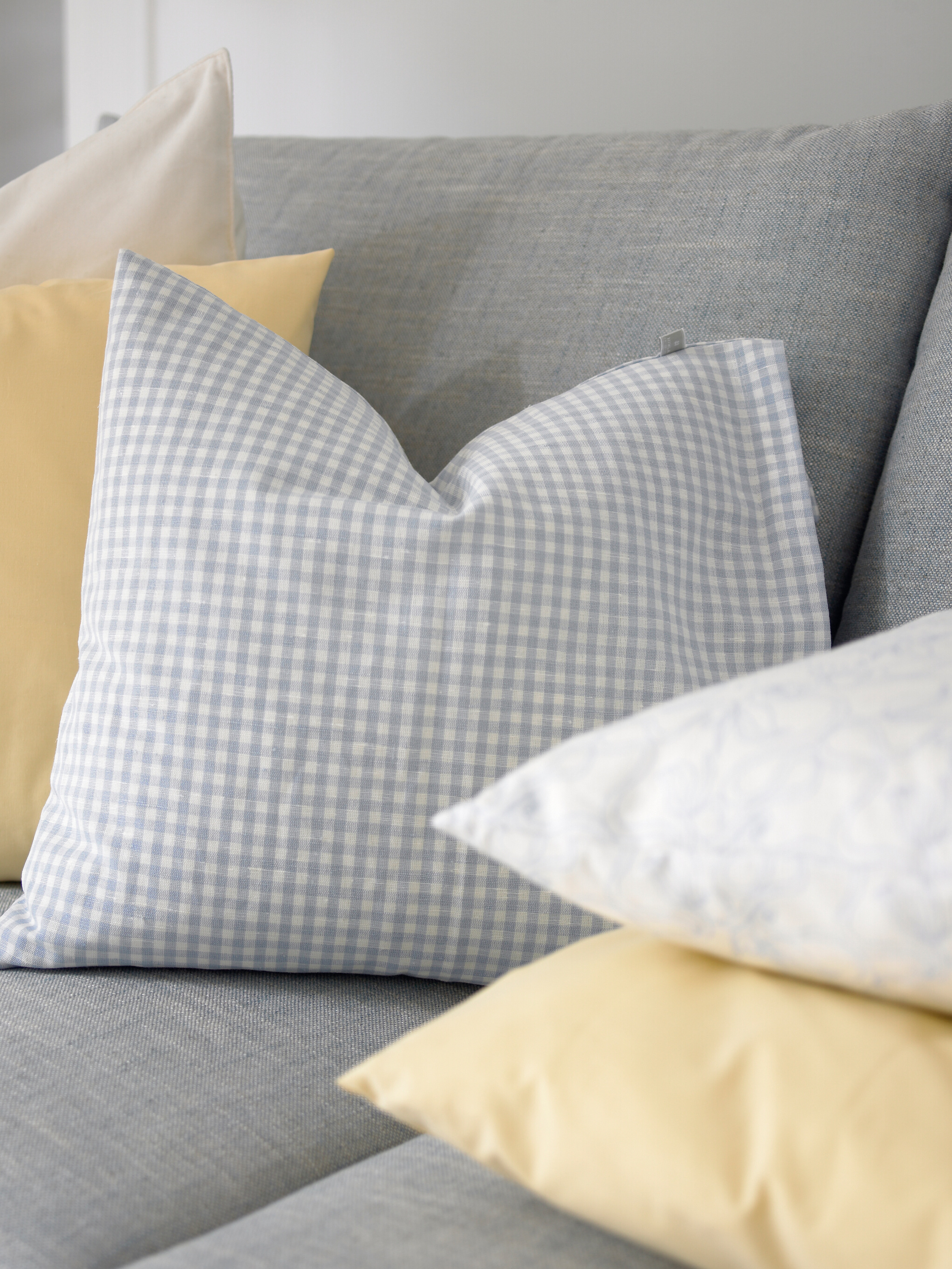 Tekstiler i ulike kvaliteter med duse toner, rutemønster og ensfarget forsterker det milde og myke uttrykket.