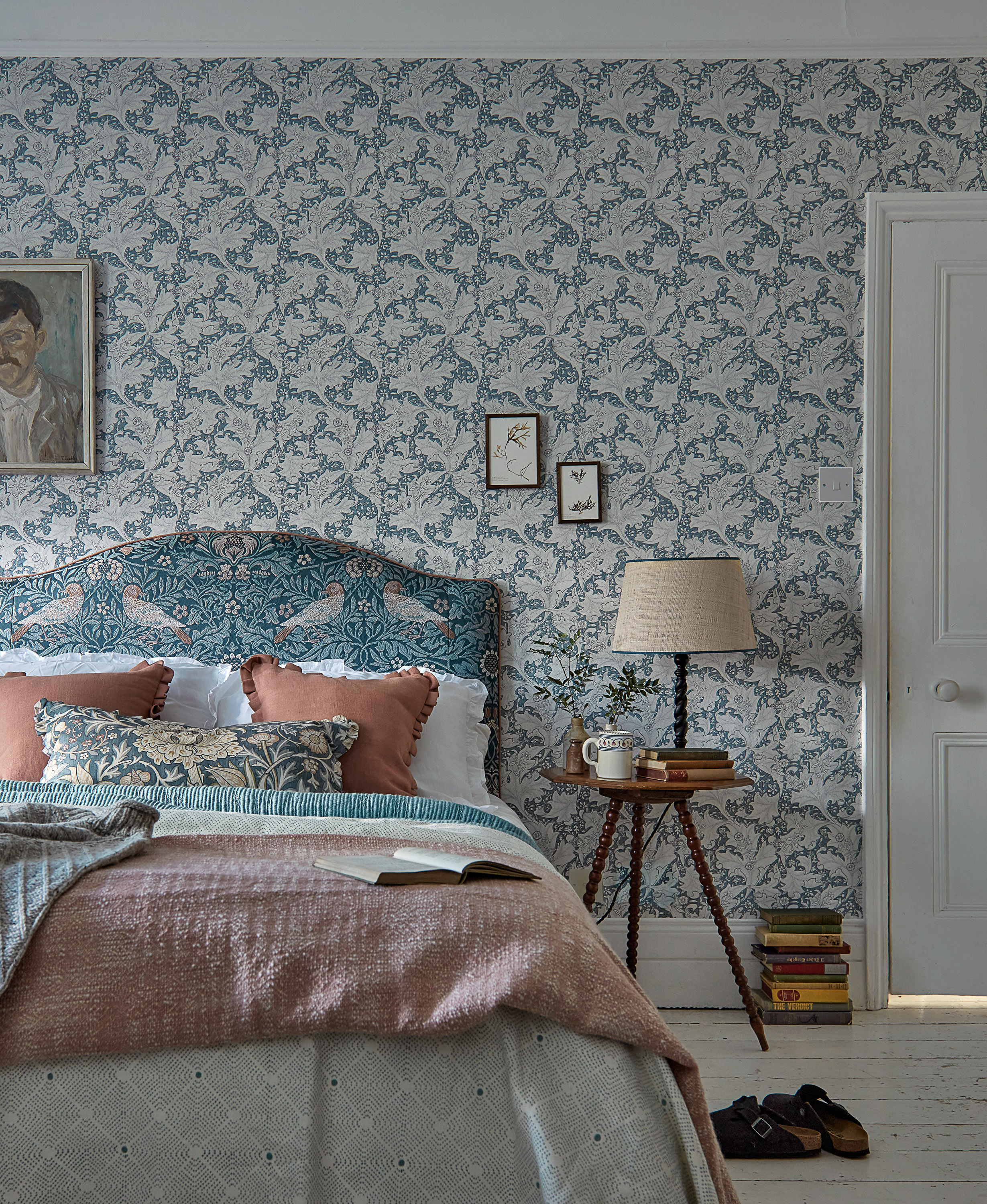 et soverom med klassisk tapet, lys farge og flere gamle gjensander