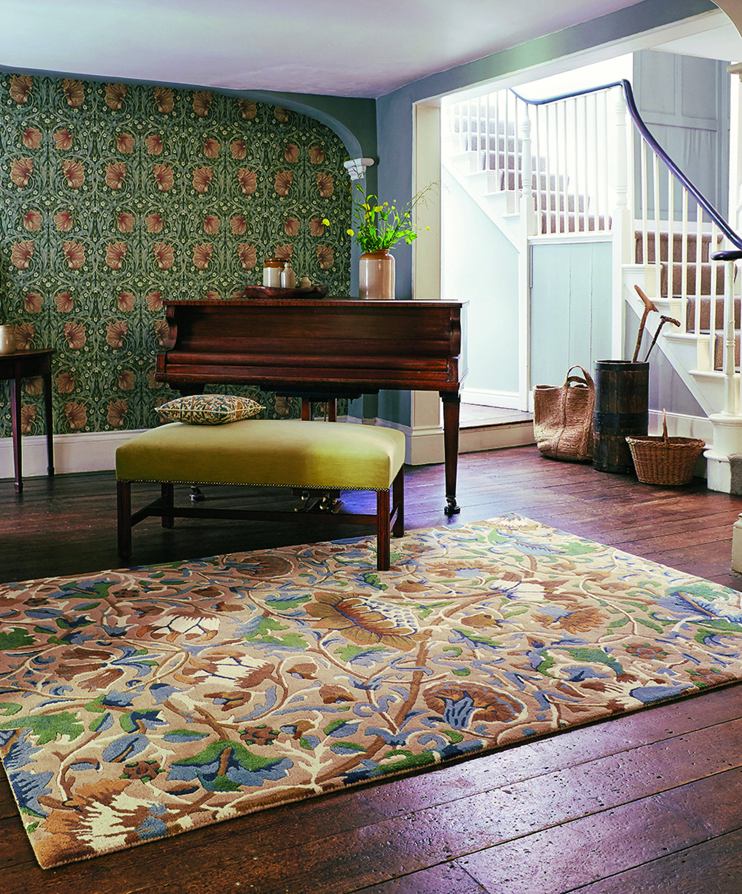 Tapet, teppe og pute i fred og fordragelighet, i samme fargepalett og med flere mønster mot hverandre. 