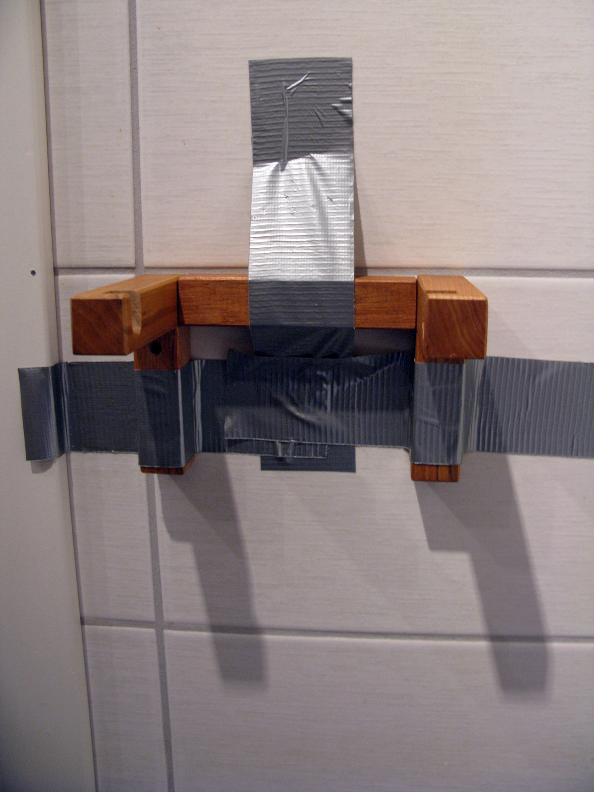 Etter 20 minutter har limet herdet nok til at tapen kan fjernes og dorullen settes på plass.