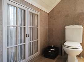 INNFELT SKAP: På dette badet er skap og hyller bygget inn i veggen. Med glassdører minner det om et vindu og bidrar til at rommet oppleves større. Smart utnyttelse av plassen, men den må inn i planen før veggene bygges.