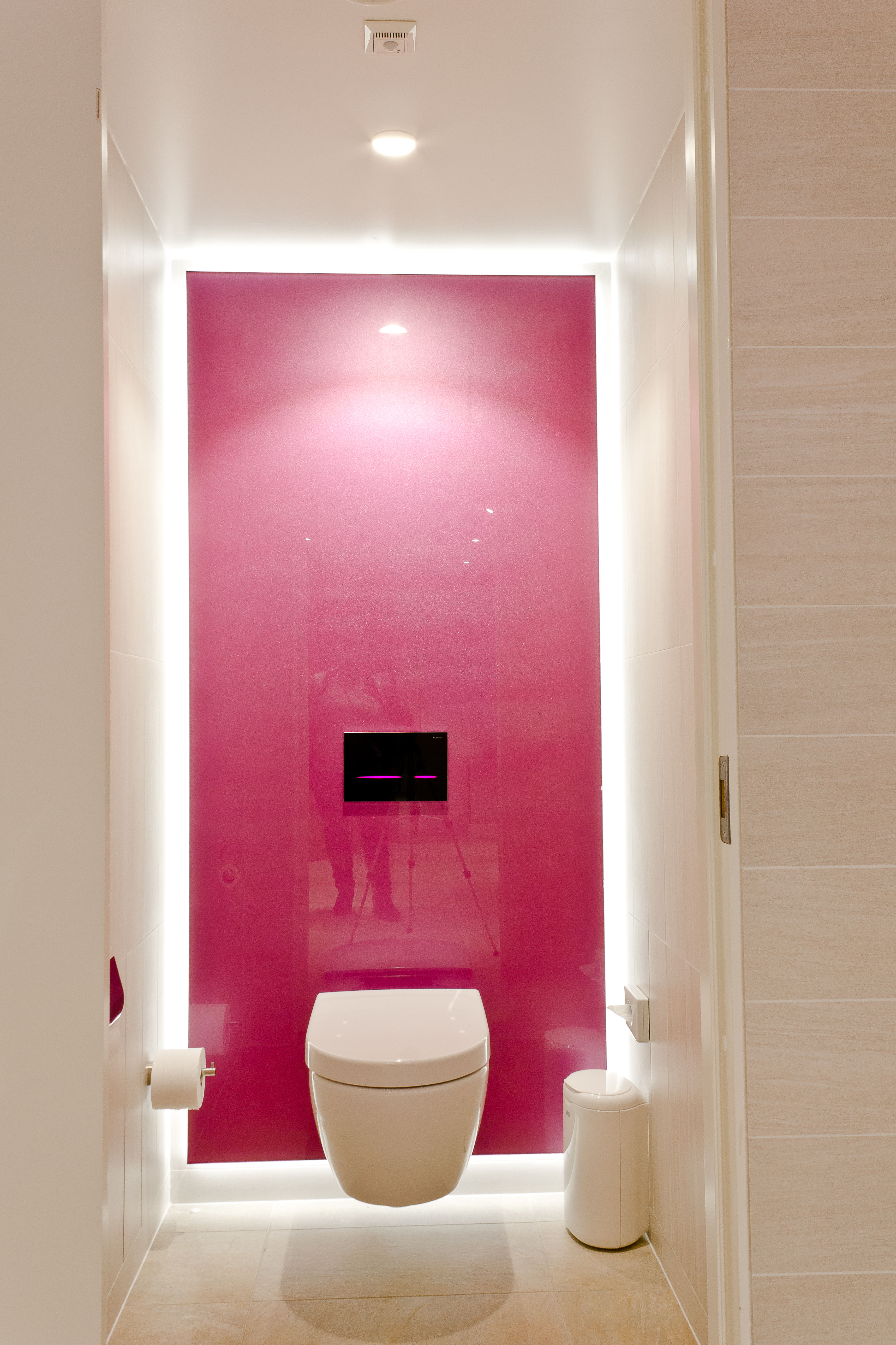 Bak det vegghengte vannklosettet er hvert avlukke dekorert med en akrylplate i en egen farge. Bevegelsesmarkøren på den berøringsfrie betjeningsplaten lyser med LED-lys i samme farge som veggen.