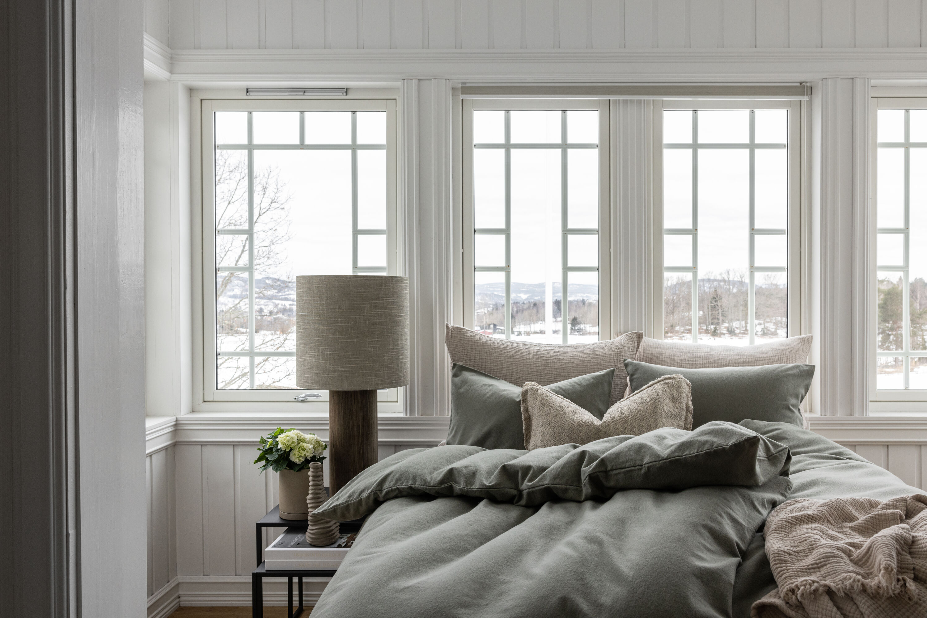 beige soverom med snø utenfor vinduet