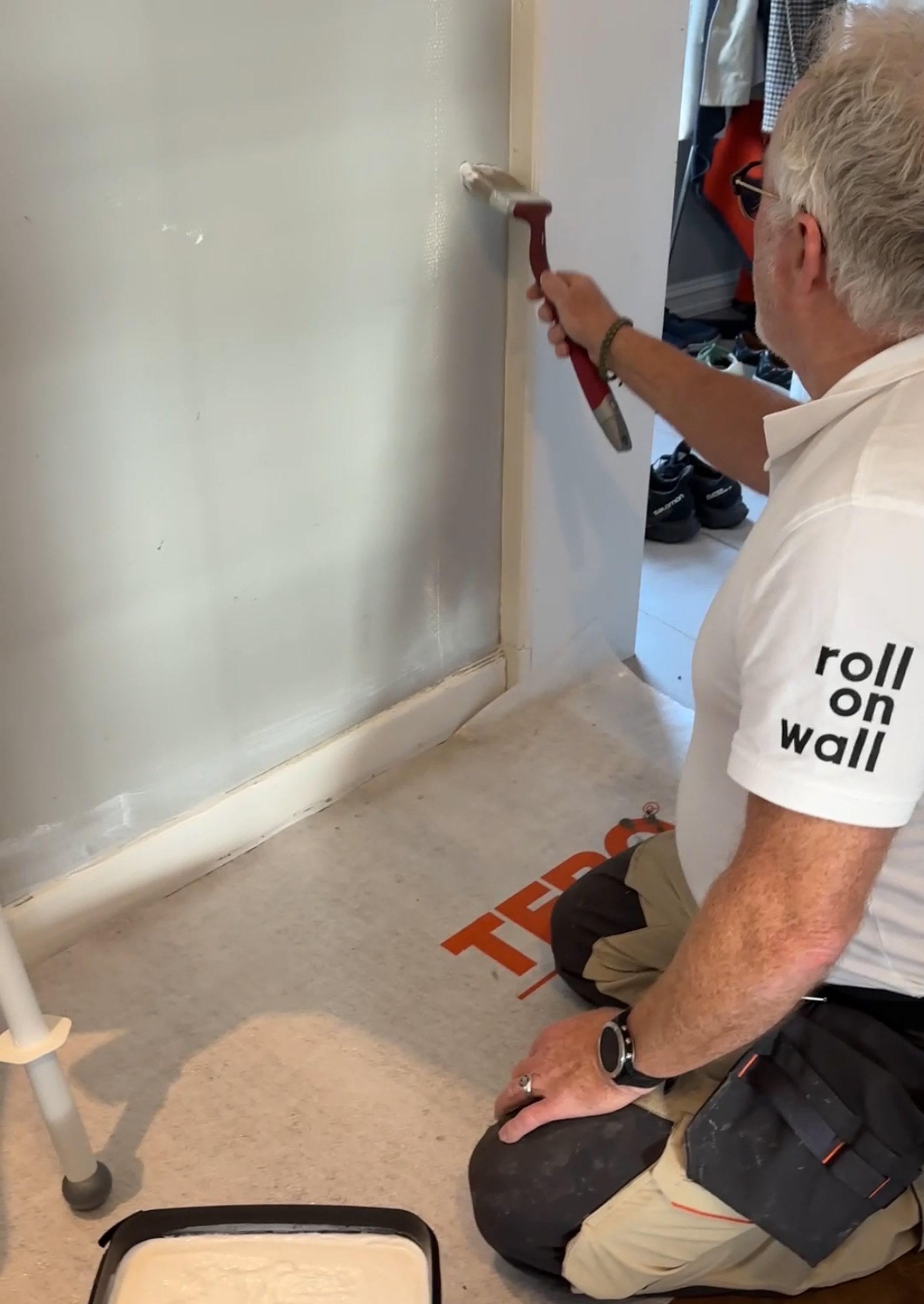 Mann påfører lim på glassfiberstrie