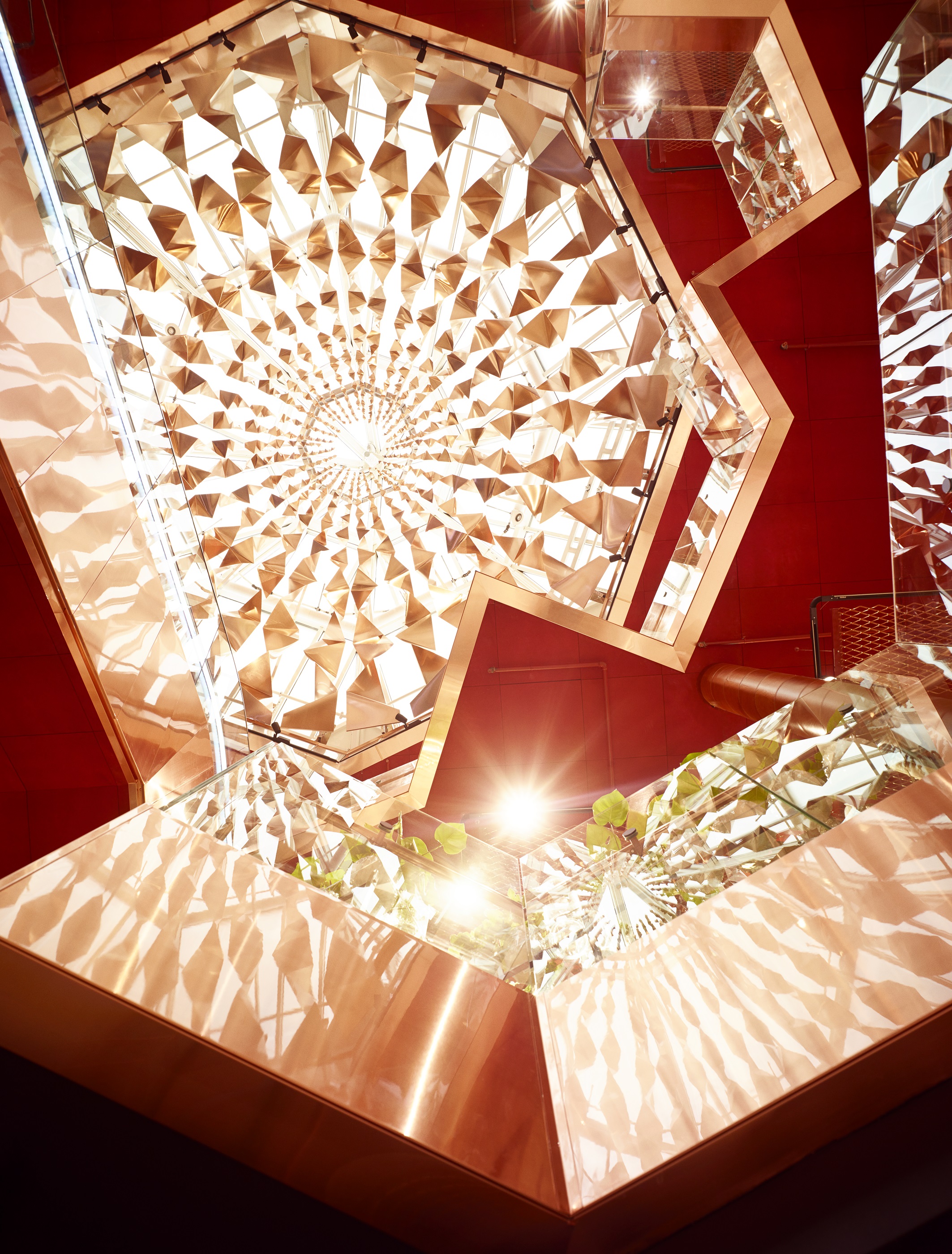 Over atriet henger en gedigen lysekrone i vridd kobber.