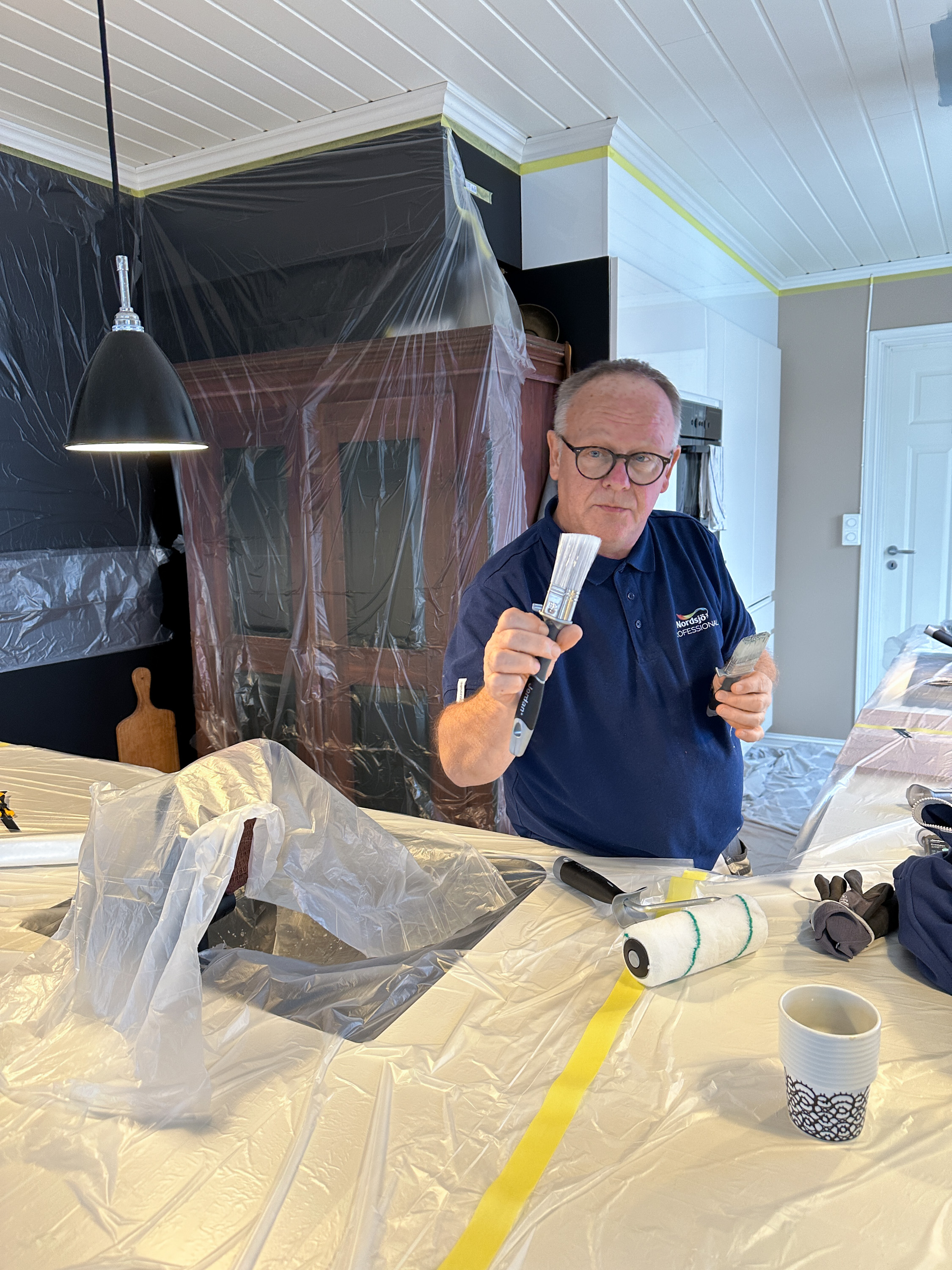 Per Myhre viser frem penslene han bruker til detaljarbeid og taklister.