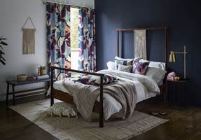 <b>FARGESPILL:</b> Kontrasten mellom hvitt og mørk blå mykes opp med gardiner i blomstermønster og flere farger. Tekstil fra Scion/Tapethuset.