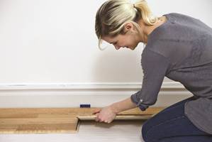 Trykk ned kiler mellom gulvet og veggen for å lage en bevegelsesfuge på cirka 10 mm.