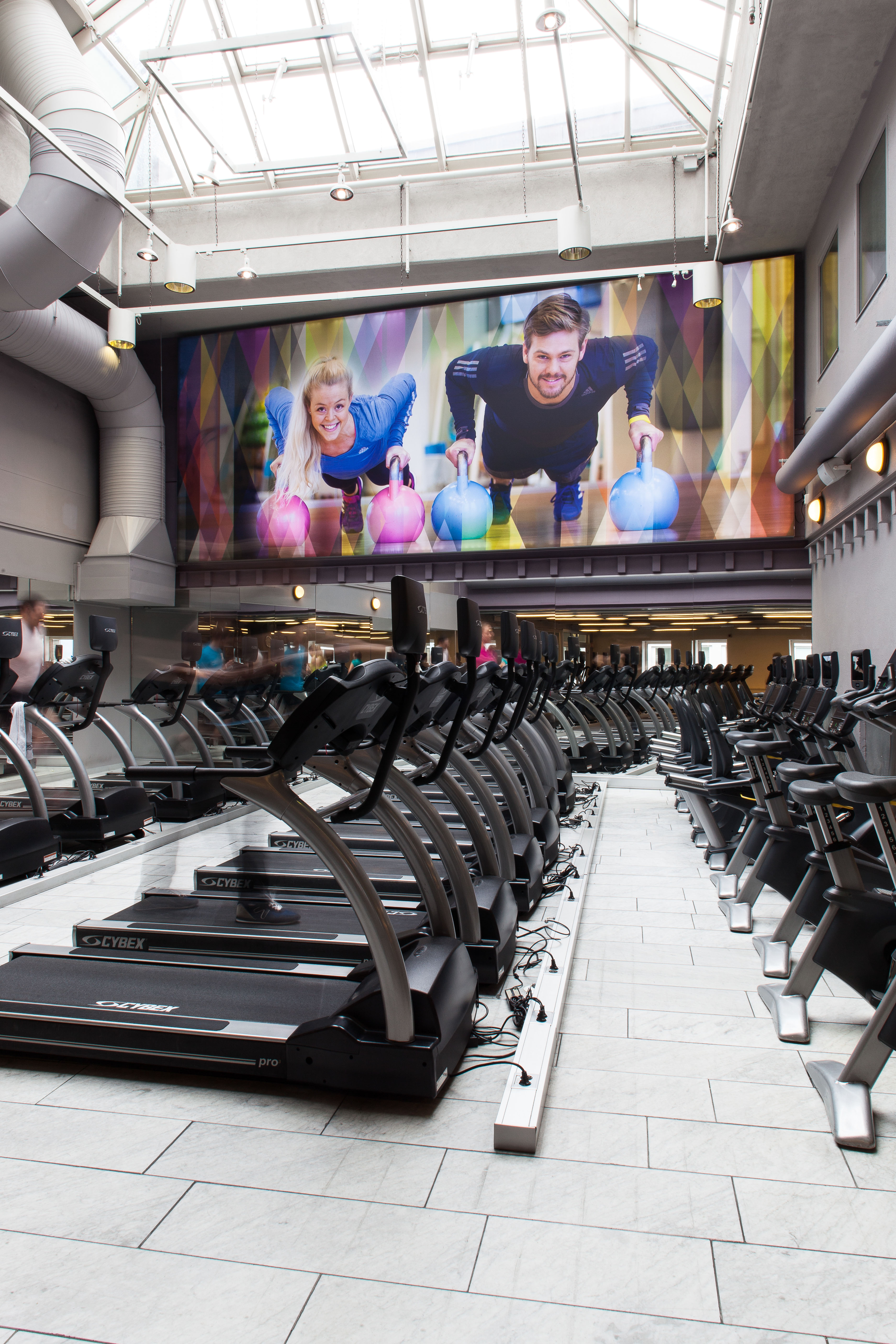 Salen for kondisjonstrening er dekorert med inspirerende bildetapet og herlig dagslys fra takvinduer høyt der oppe.