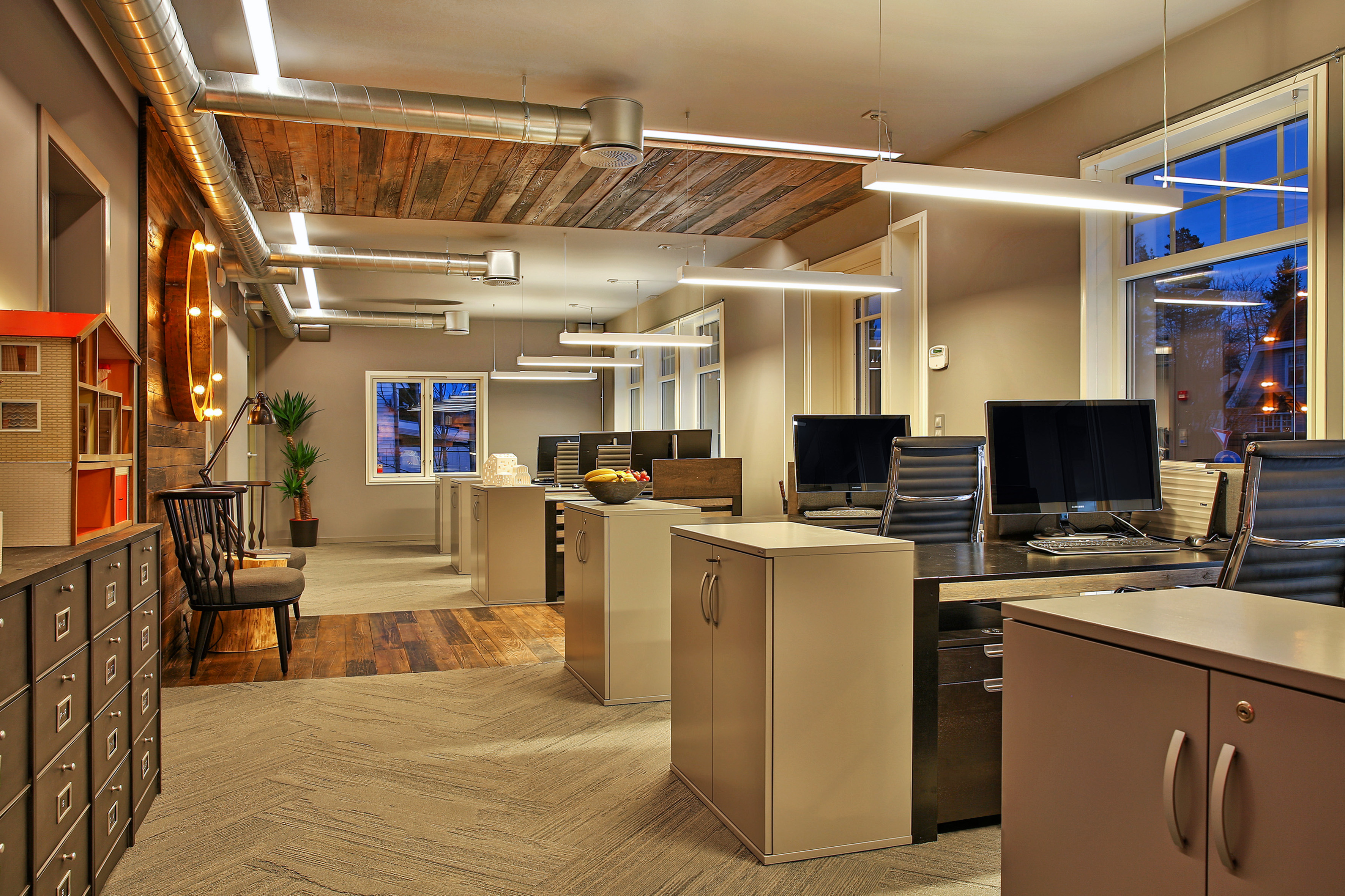 De gamle materialene er hentet fra en nærliggende låve og i tillegg til å bryte gulvflaten, fortsetter de videre på veggen og over i taket - den gamle låveveggen har altså fått en ny funksjon.