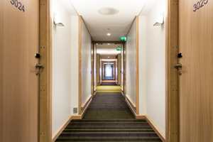 Teppene i korridoren baserer seg på to hovedfarger, røde og grønne fargevariasjoner, med hjelp av en mørk antrasitt bakgrunn. De fargede stripene i teppene skaper endring i intensitet og distanse.