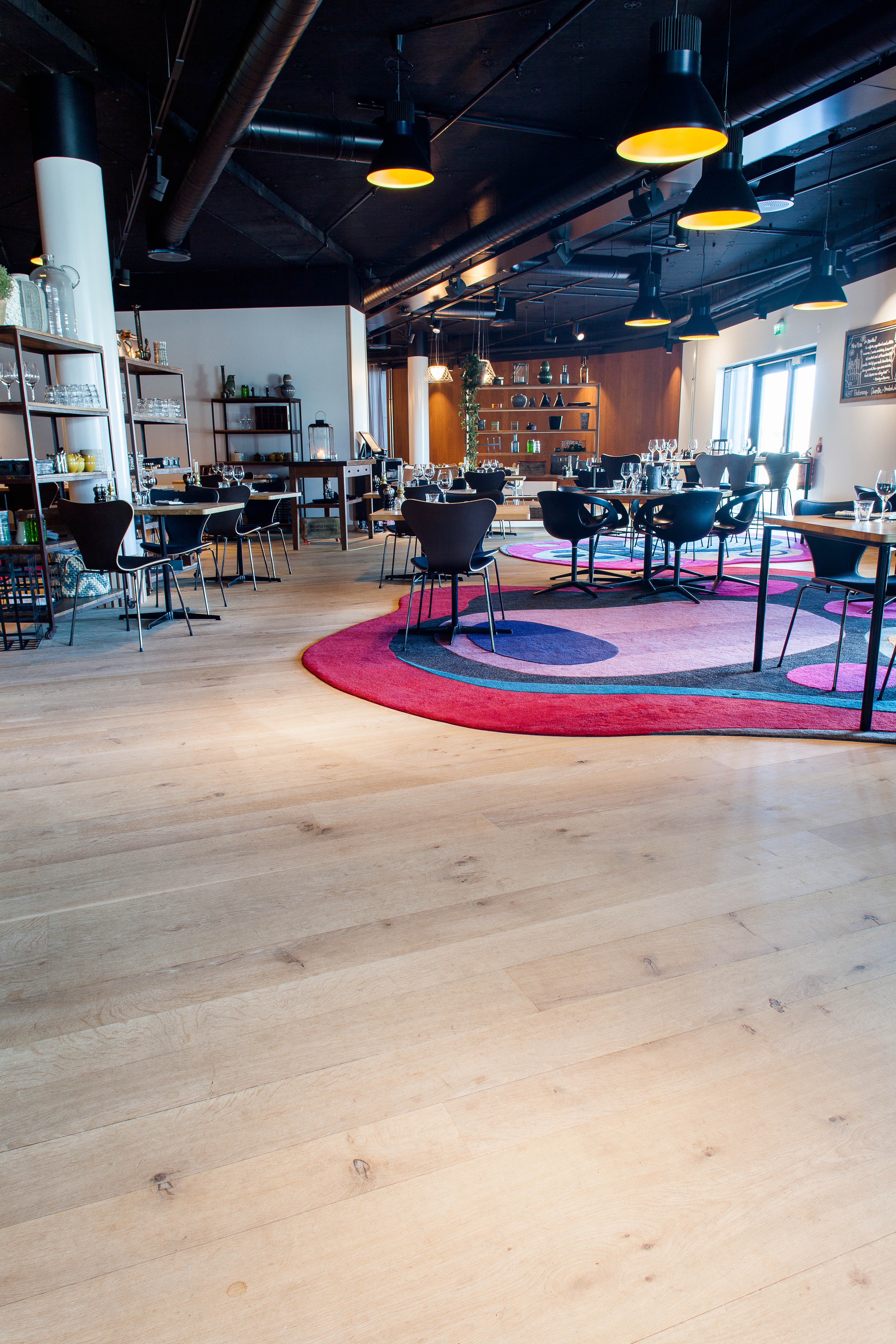 Innover i restaurantområdene er det også overflater av tre som dominerer, supplert av spesialdesignede tepper i sterke farger.