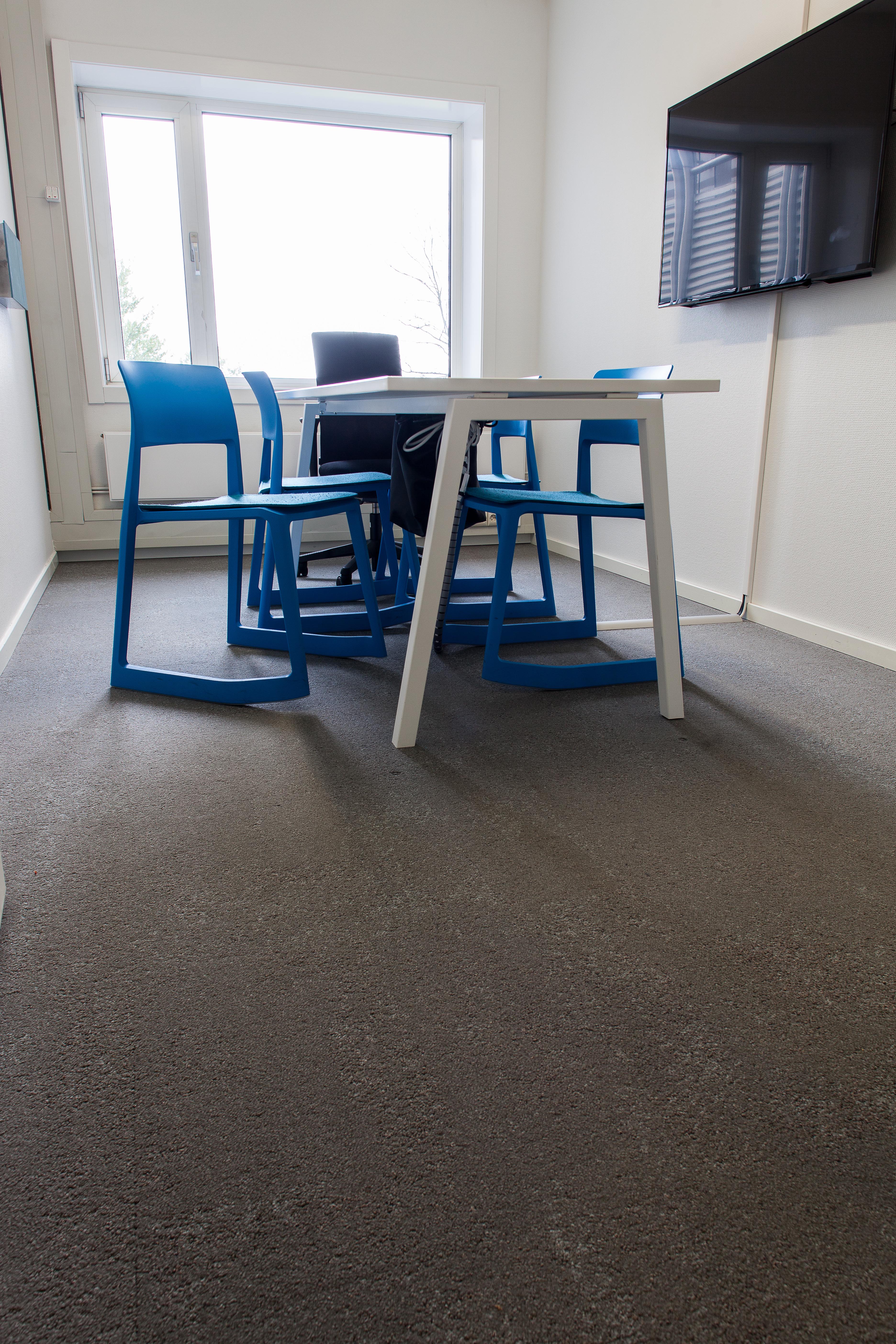 Møterommets mørke teppefliser fungerer godt sammen med fargerike interiørdetaljer.